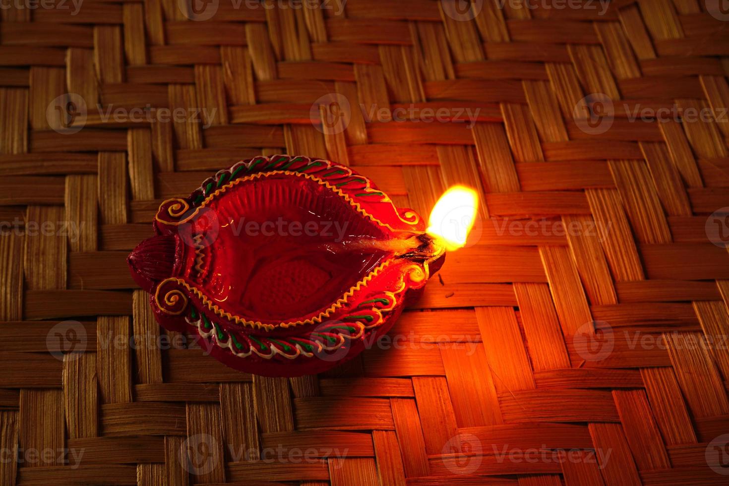 Happy Diwali - Diya lamps lit during Diwali celebration. Colourful and decorated lantern are lit in night on this occassion with flower rangoli, sweets and gifts. photo