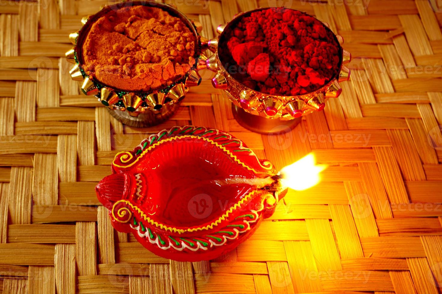 Happy Diwali - Diya lamps lit during Diwali celebration. Colourful and decorated lantern are lit in night on this occassion with flower rangoli, sweets and gifts. photo