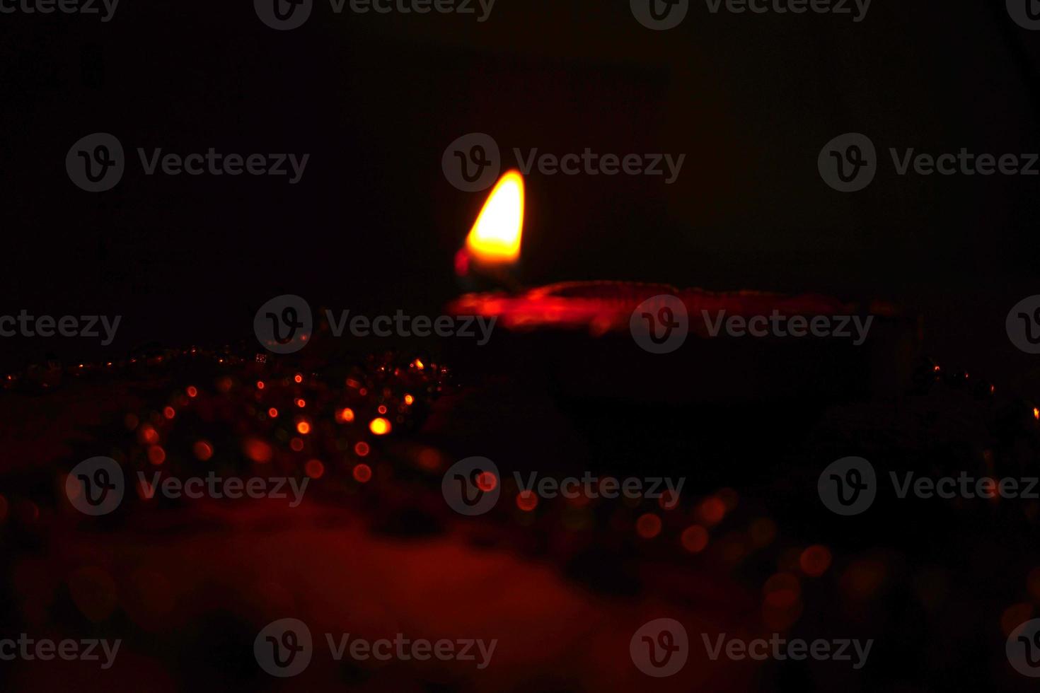 Happy Diwali - Diya lamps lit during Diwali celebration. Colourful and decorated lantern are lit in night on this occassion with flower rangoli, sweets and gifts. photo