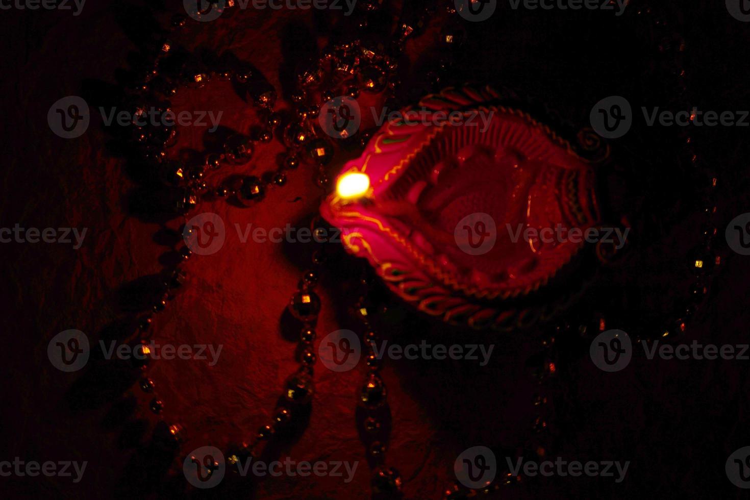 Happy Diwali - Diya lamps lit during Diwali celebration. Colourful and decorated lantern are lit in night on this occassion with flower rangoli, sweets and gifts. photo