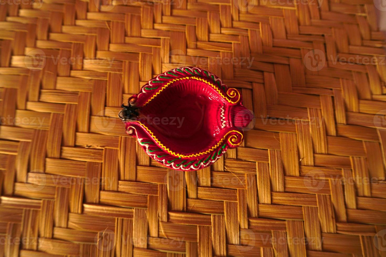 Happy Diwali - Diya lamps lit during Diwali celebration. Colourful and decorated lantern are lit in night on this occassion with flower rangoli, sweets and gifts. photo