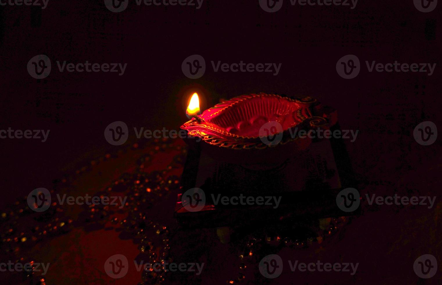 Happy Diwali - Diya lamps lit during Diwali celebration. Colourful and decorated lantern are lit in night on this occassion with flower rangoli, sweets and gifts. photo