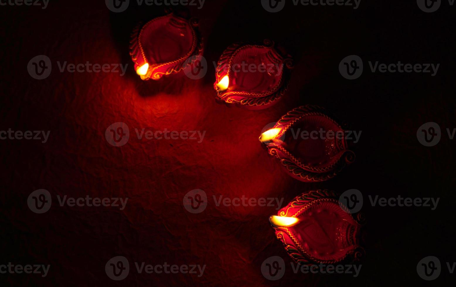 Happy Diwali - Diya lamps lit during Diwali celebration. Colourful and decorated lantern are lit in night on this occassion with flower rangoli, sweets and gifts. photo