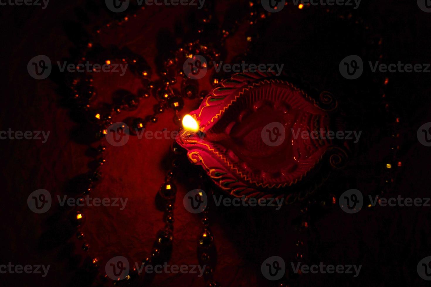 Happy Diwali - Diya lamps lit during Diwali celebration. Colourful and decorated lantern are lit in night on this occassion with flower rangoli, sweets and gifts. photo