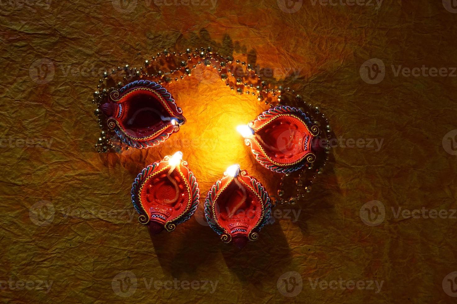 Happy Diwali - Diya lamps lit during Diwali celebration. Colourful and decorated lantern are lit in night on this occassion with flower rangoli, sweets and gifts. photo