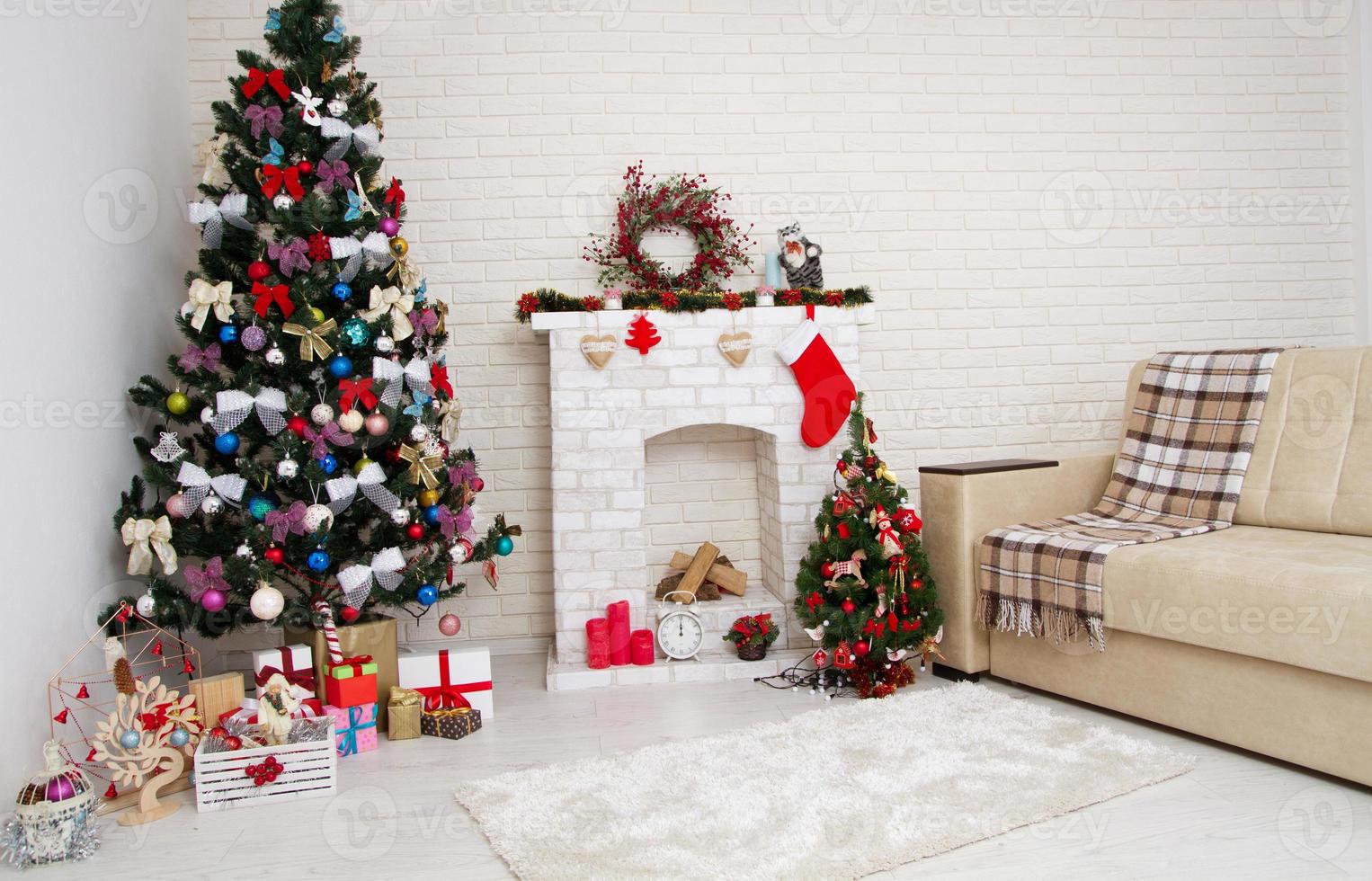 Christmas decor of bright stylish living room with vintage sofa, fireplace, Christmas tree and red candles, new year concept photo