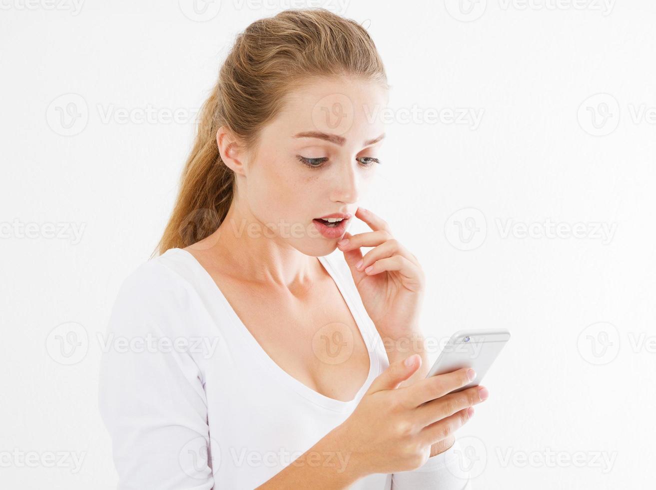 attractive girl reading something exciting on mobile phone photo