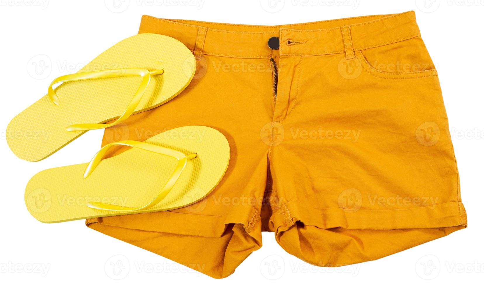 Close up orange shorts and summer slippers isolated on white background photo