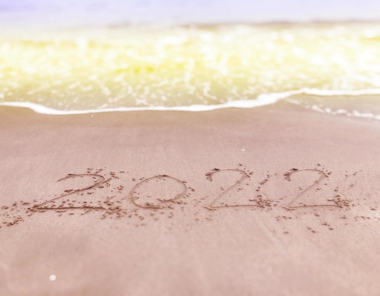 Happy new year , lettering numbers 2022 year on the sand photo