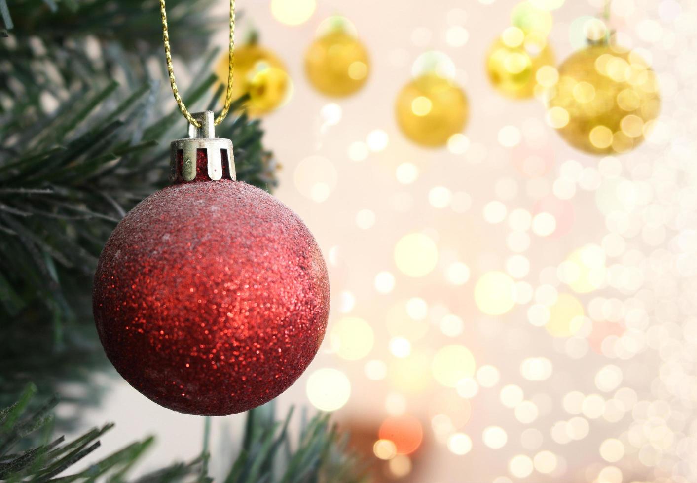 Red Christmas ball hanging on Christmas tree with bokeh photo