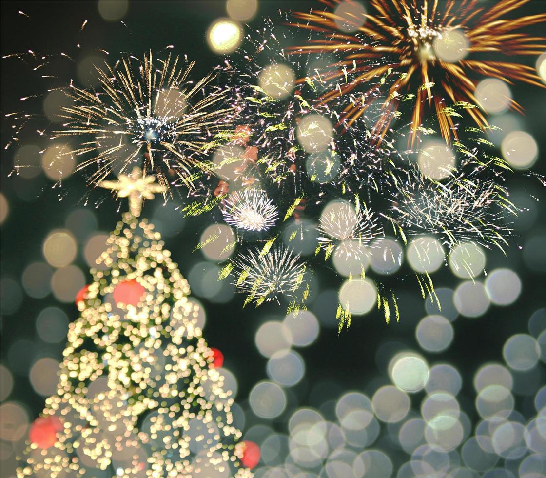 Árbol de Navidad sobre un fondo de fuegos artificiales con bokeh borrosa foto