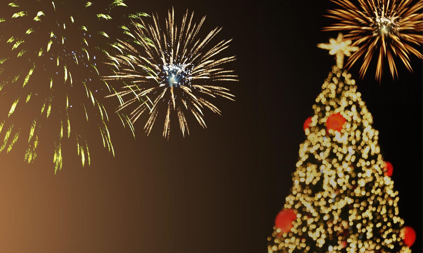 árbol de navidad en un fondo de fuegos artificiales foto