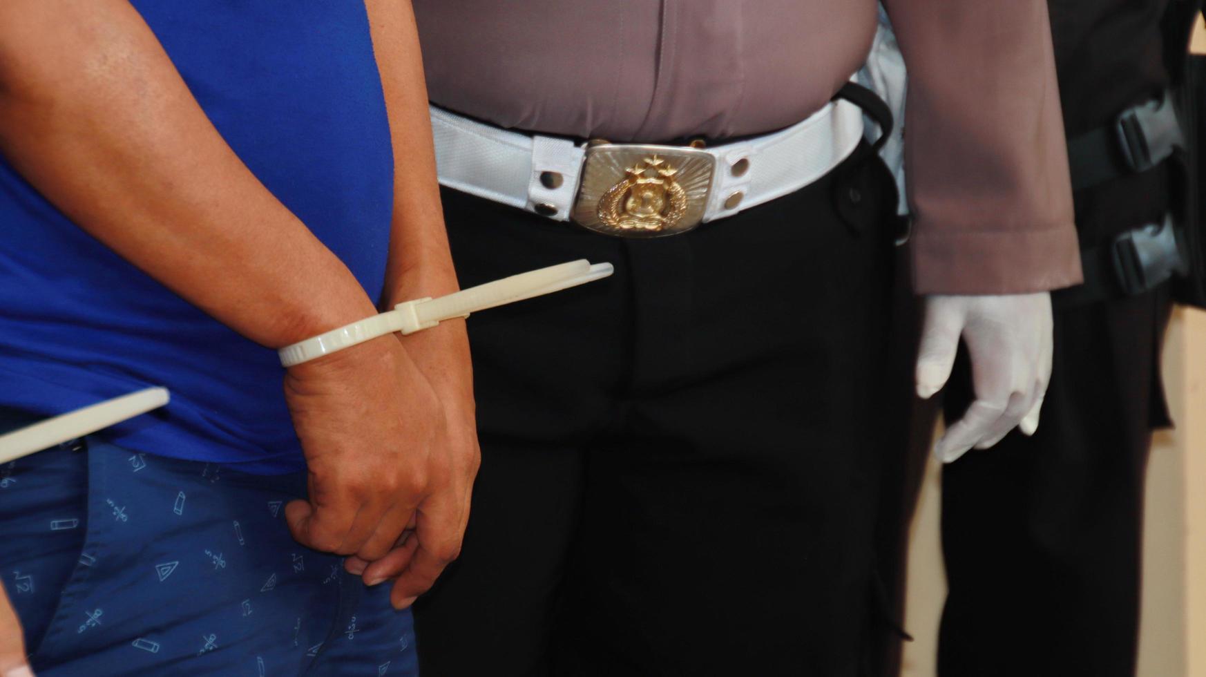 Hands of a criminal suspect in handcuffs, with plastic handcuffs photo