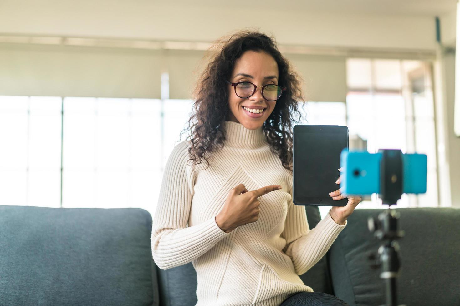 Latin woman influencer shooting video and talking with camera for blog photo