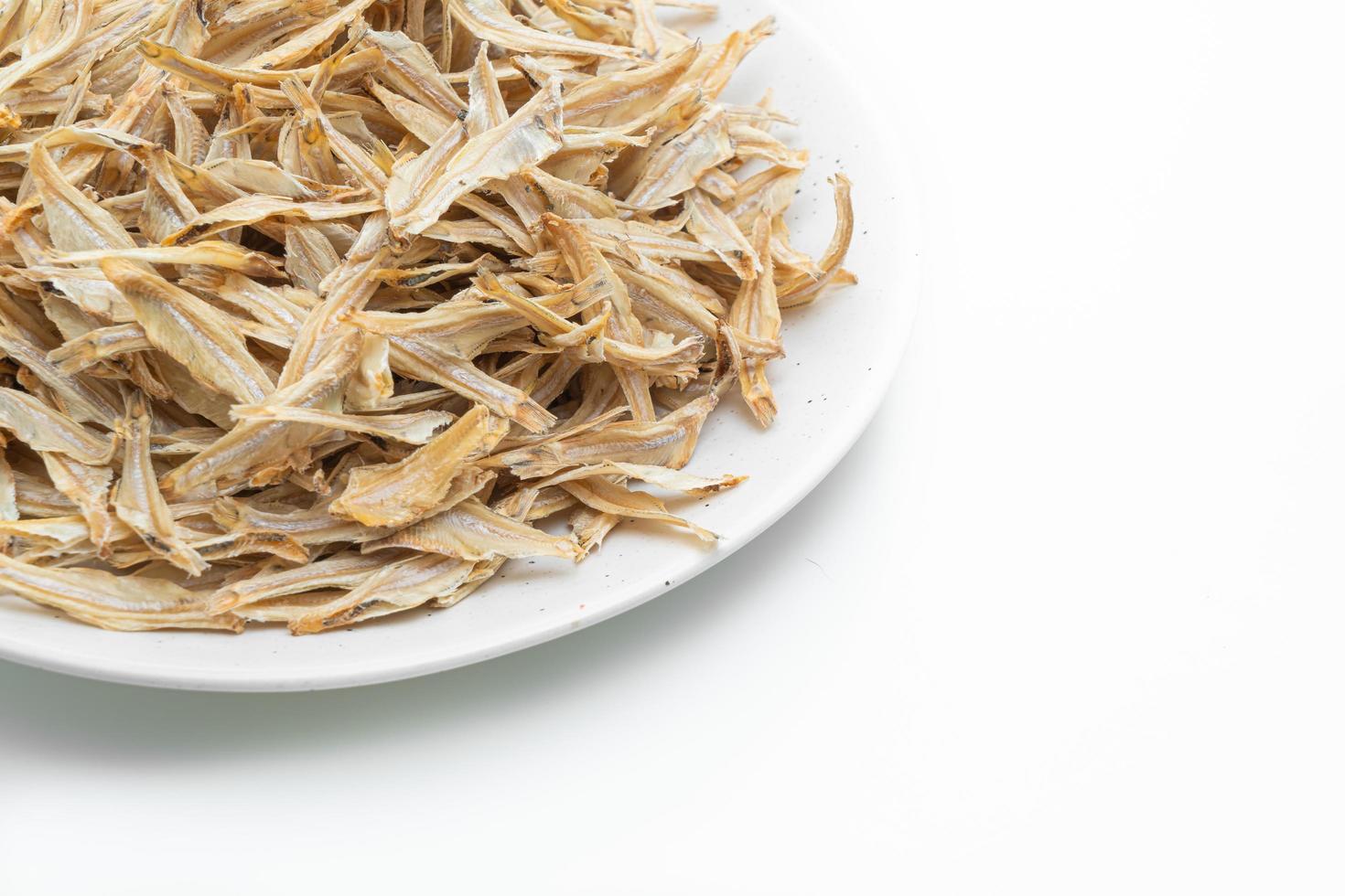 dried small crispy fish on white background photo