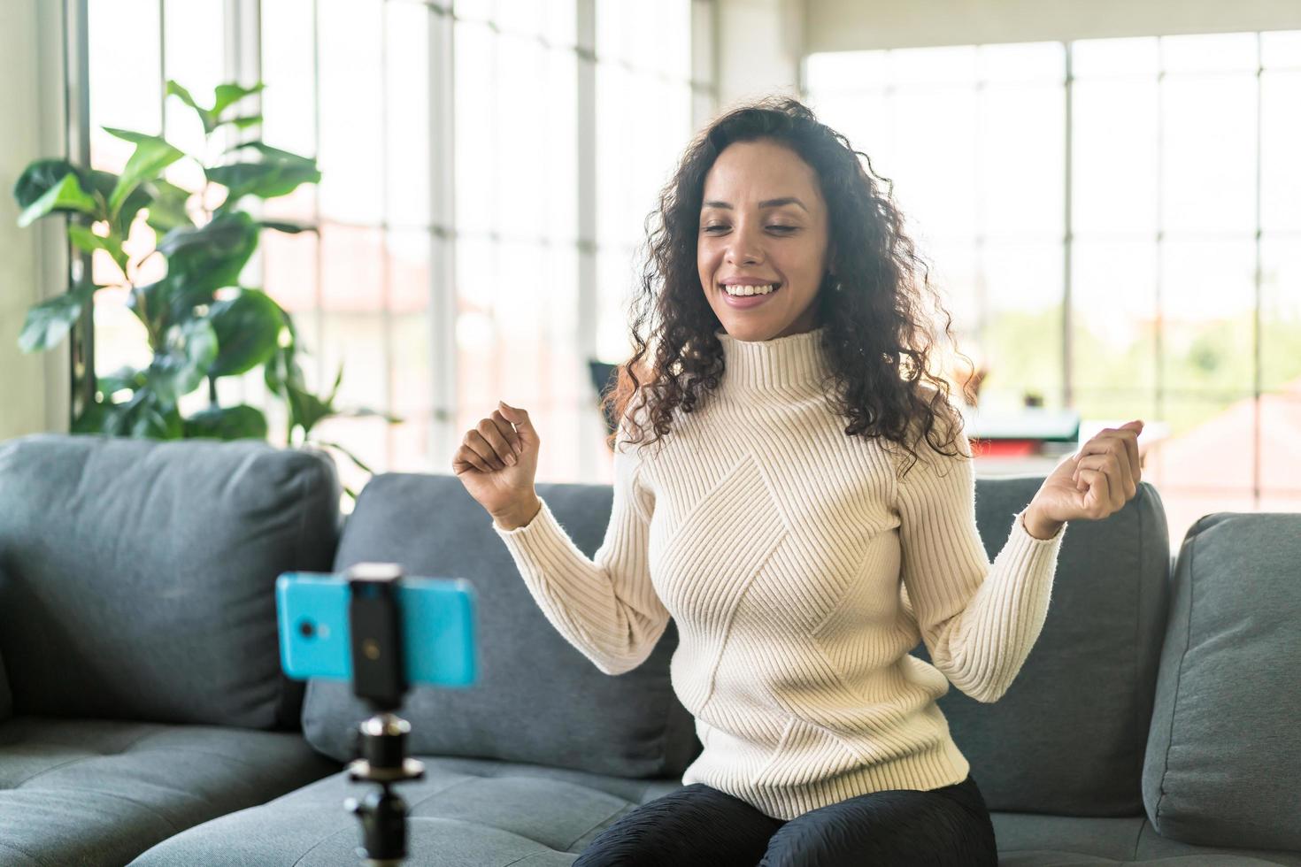 Latin woman influencer shooting video and talking with camera for blog photo