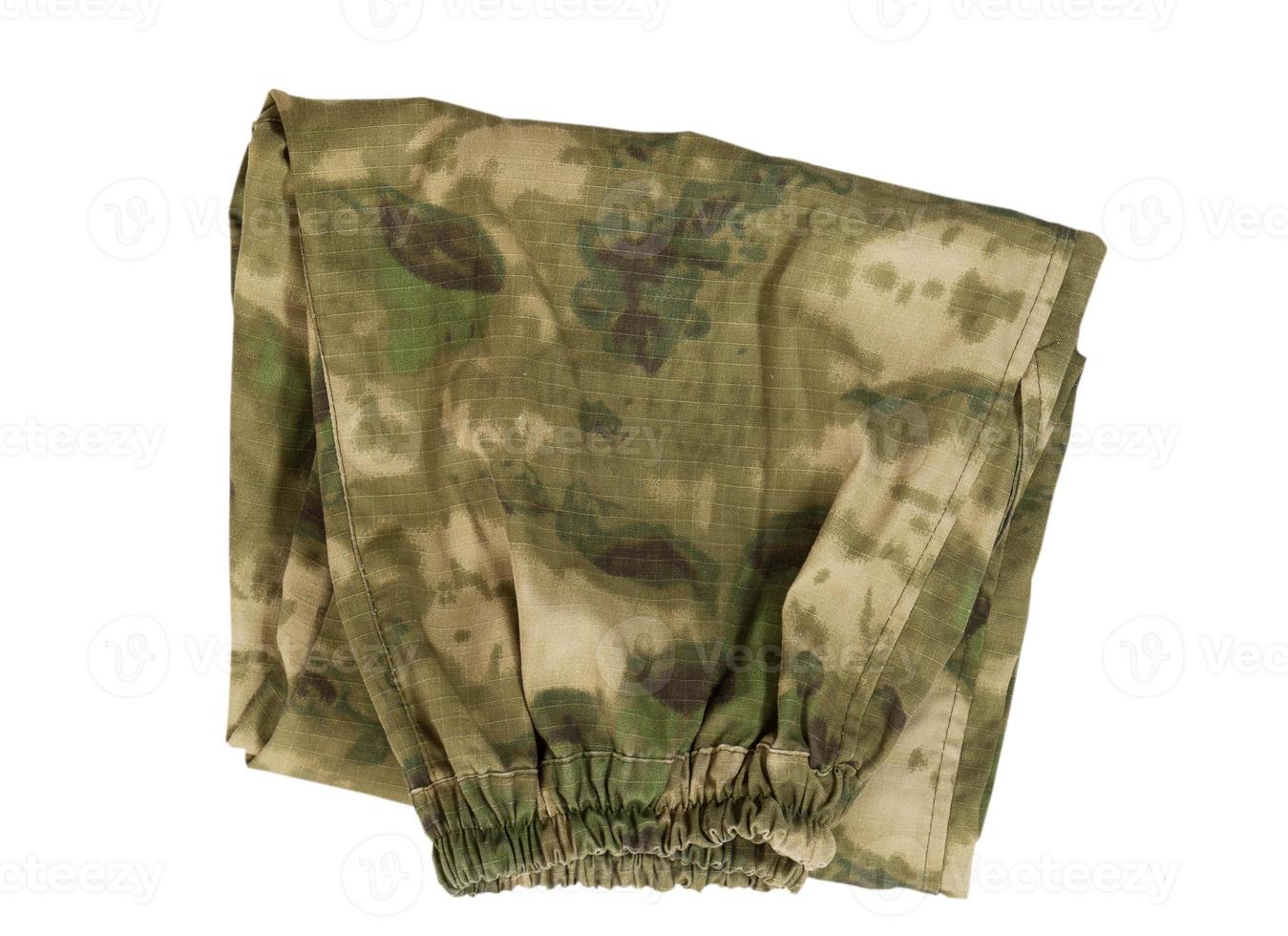 Folded trousers with a camouflage pattern on a white background, Folded camouflage pants on isolated white background, pants over white photo