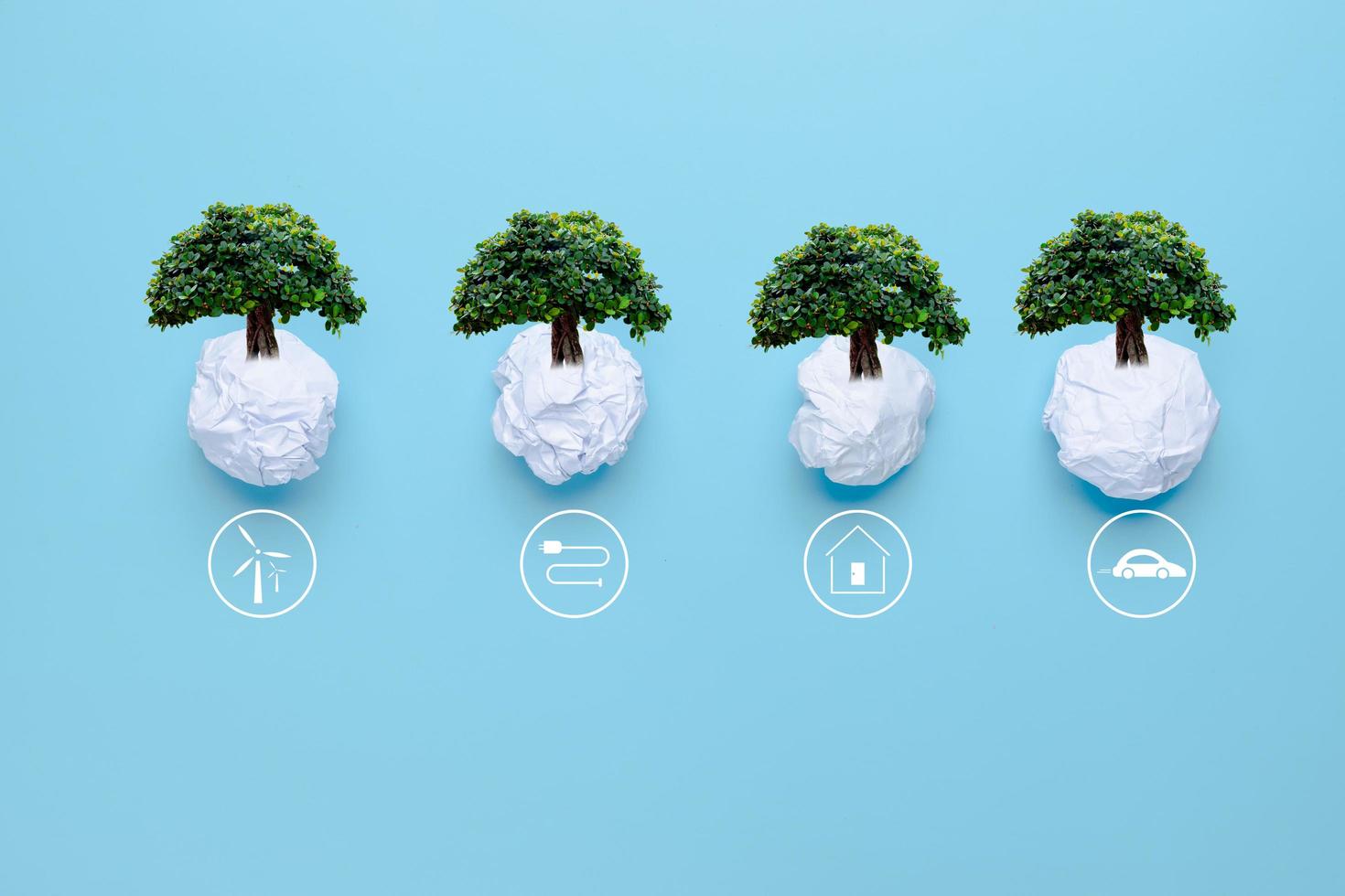 waste paper with big tree on blue background with icons energy sources for renewable, solar cells energy, sustainable development. Ecology and environment concept. photo