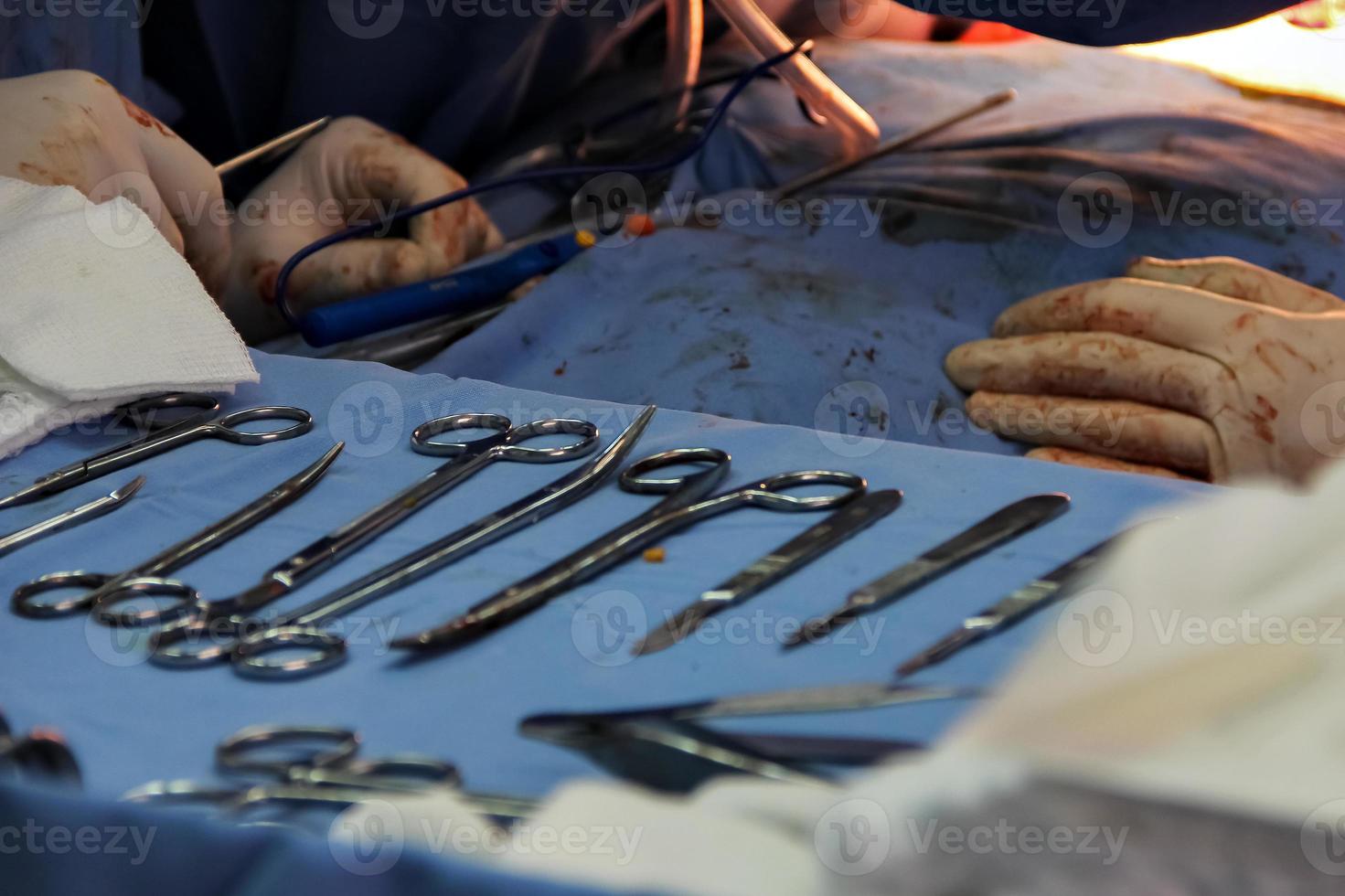 Surgical instruments table and in the background the doctors performing surgery photo