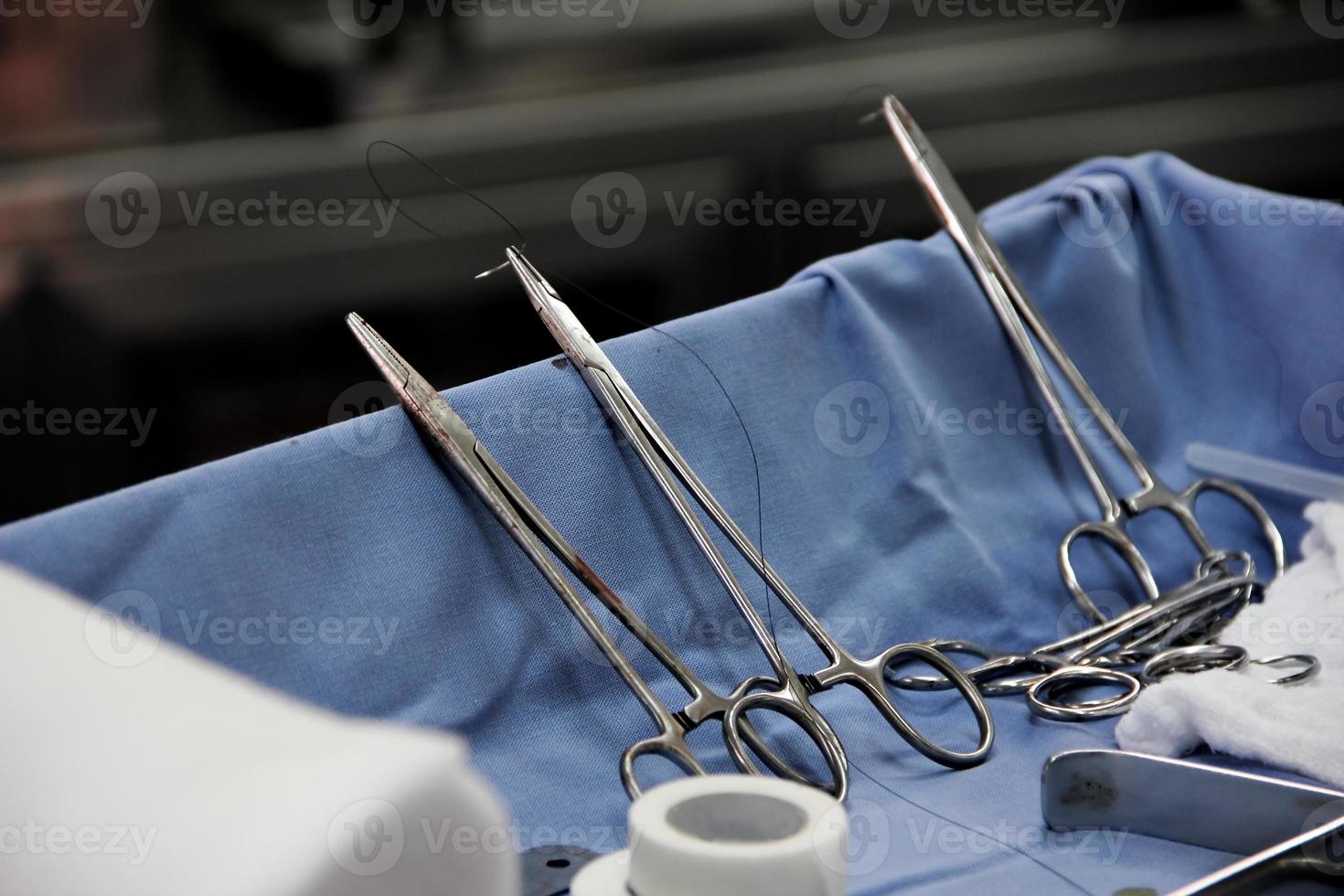 Close-up of scissors with thread and needle in an operating room. photo