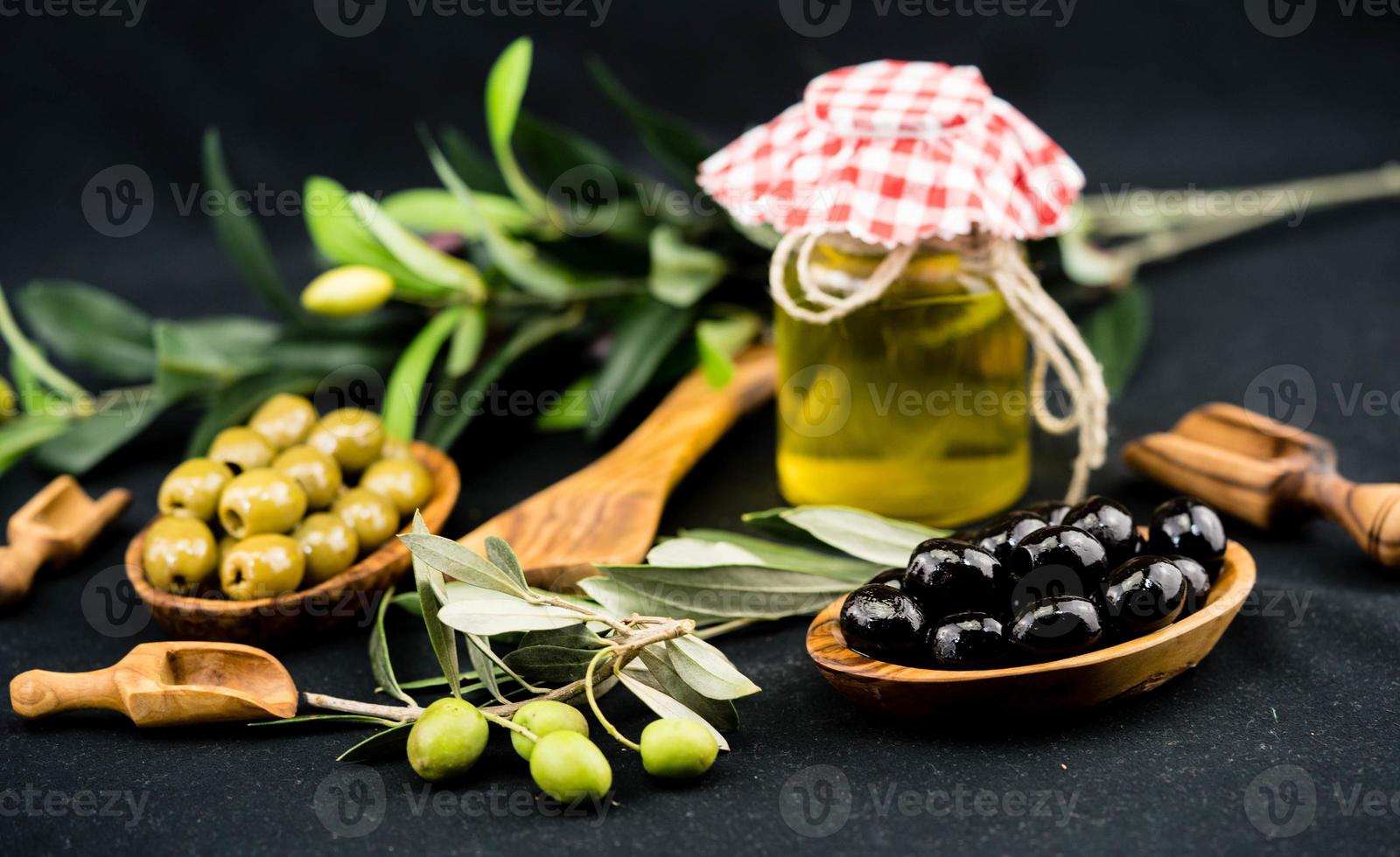 aceite de oliva prensado en frío con rama y frutos foto