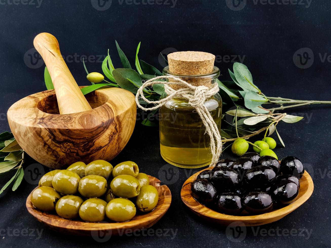 aceite de oliva prensado en frío con rama y frutos foto