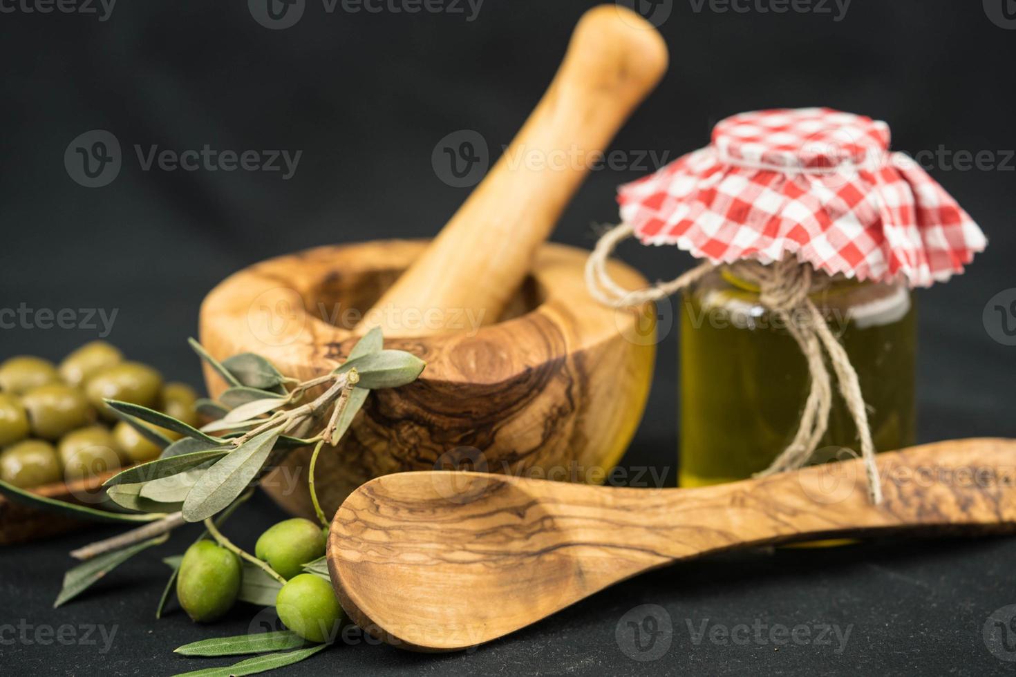 cold pressed olive oil with branch and fruits photo