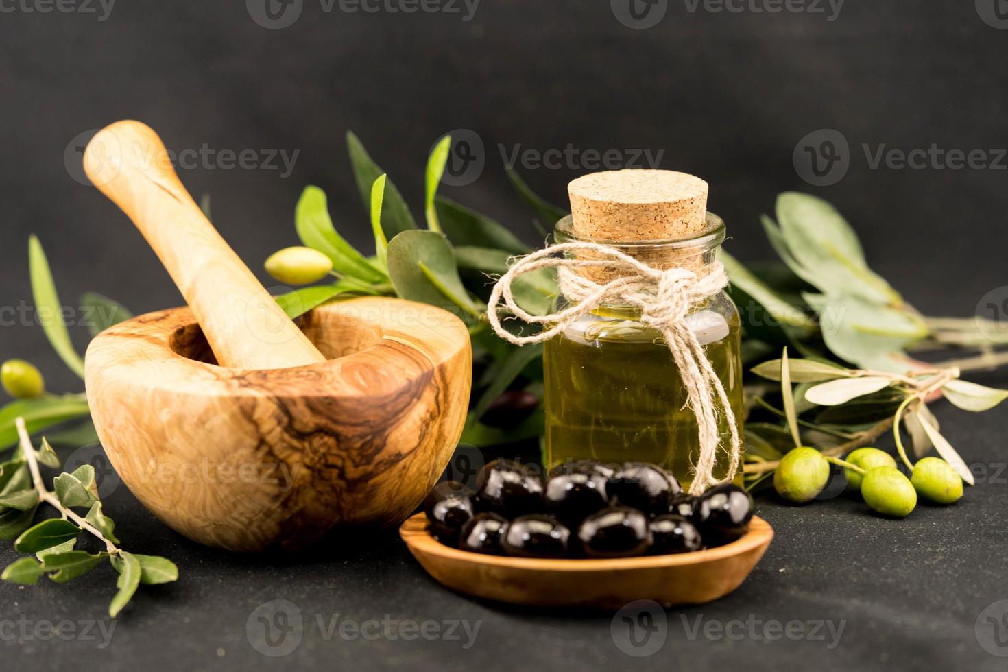 cold pressed olive oil with branch and fruits photo