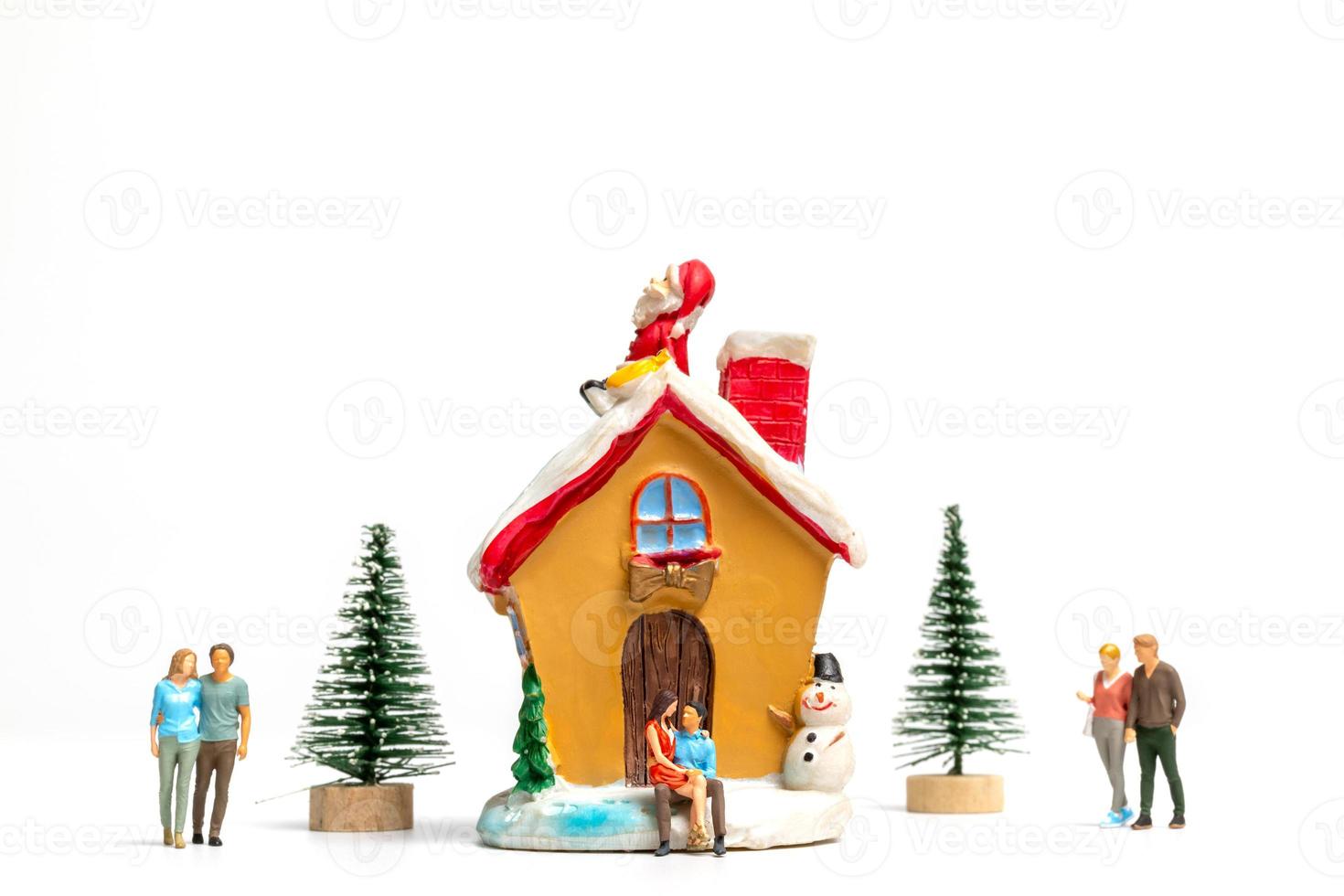 Miniature people celebrating Christmas at home photo