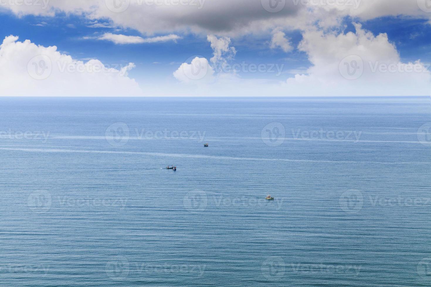 Nubes blancas en el cielo azul dejando el horizonte sobre un mar azul foto