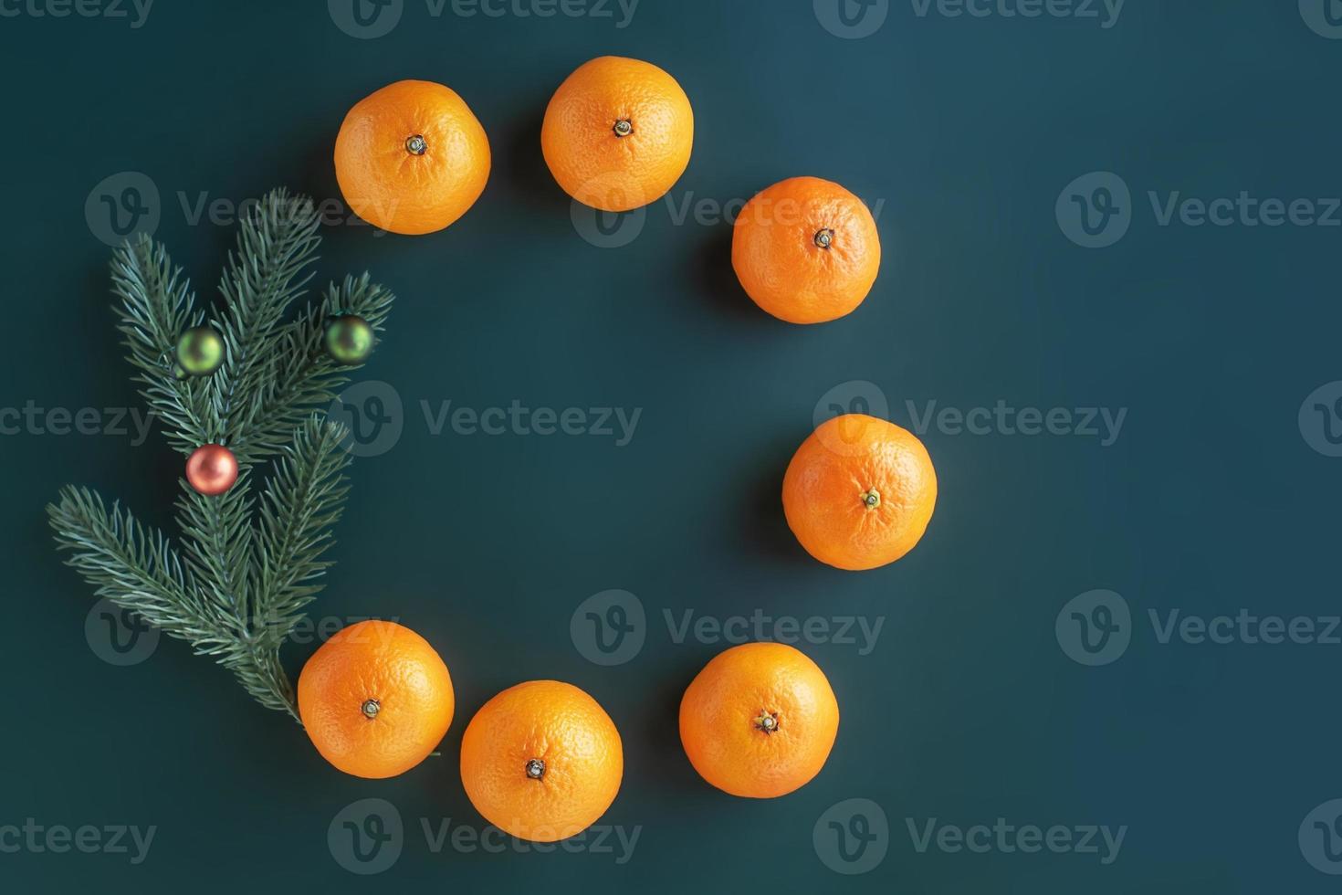 Christmas composition on a green background. Christmas tree with toys and fresh tangerines. photo