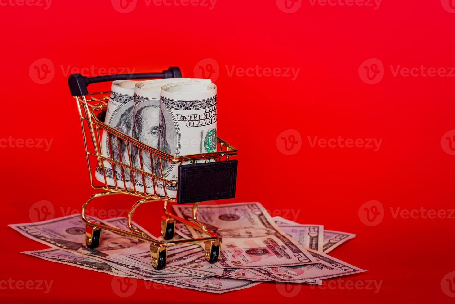 Trolley and money. Financial crisis or shopaholic concept. Mini shopping cart with money dollars. photo