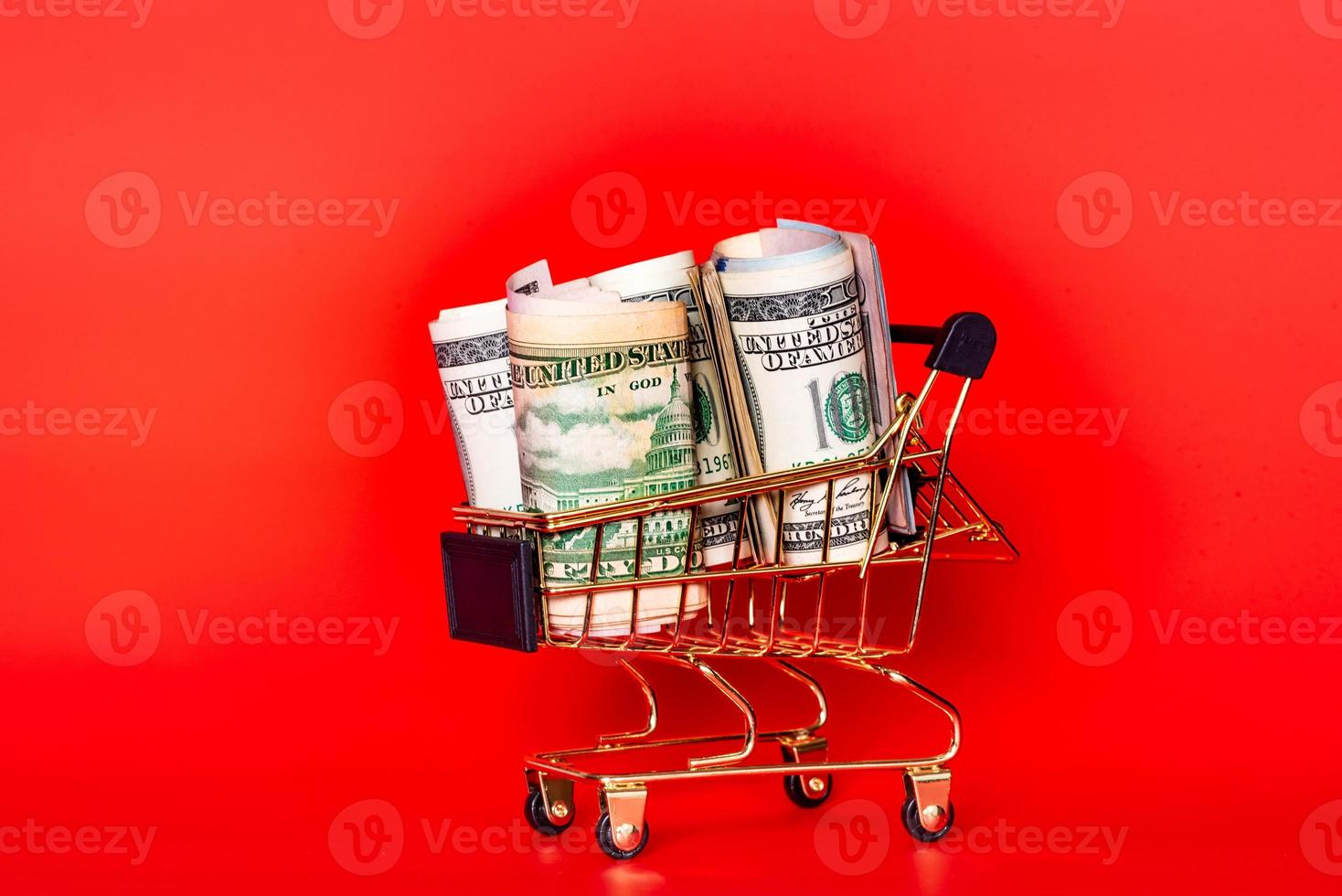 Trolley and money. Financial crisis or shopaholic concept. Mini shopping cart with money dollars. photo