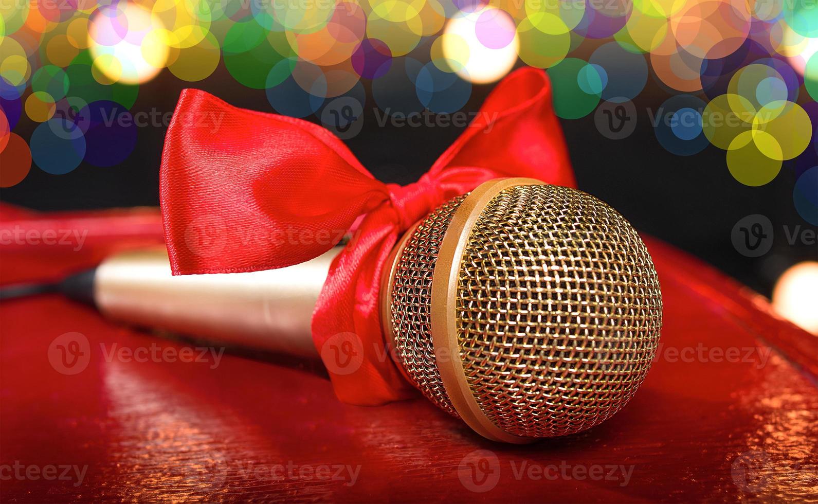 gold microphone on red wooden and dark backgrounds with many lights photo