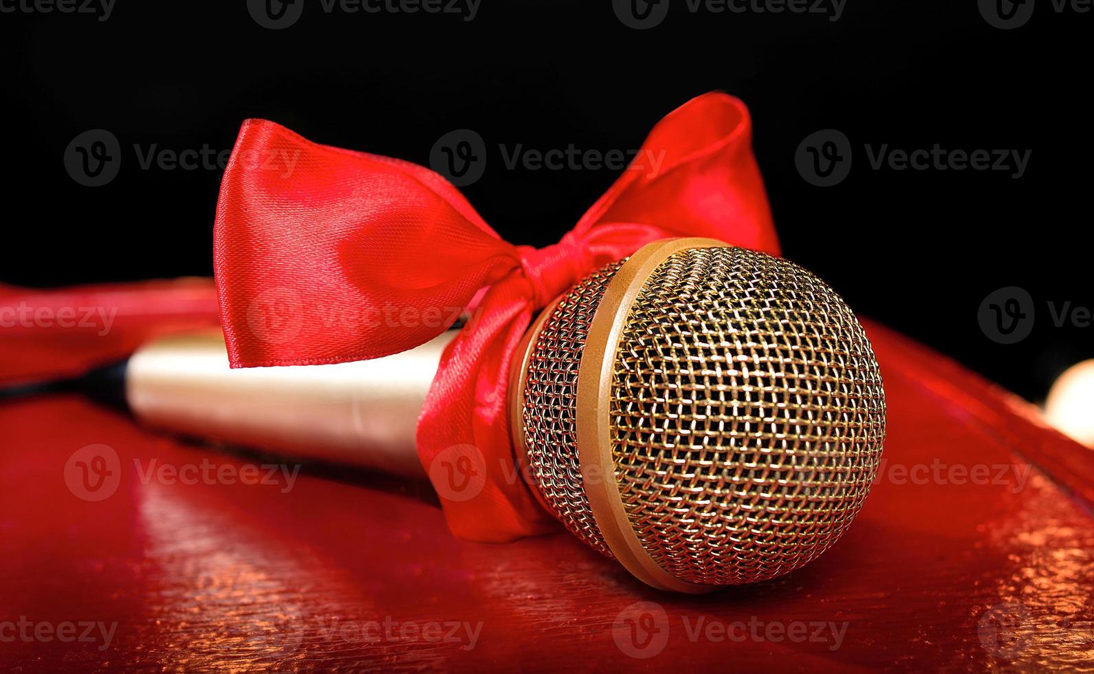 gold microphone on red wooden and dark backgrounds with many lights photo