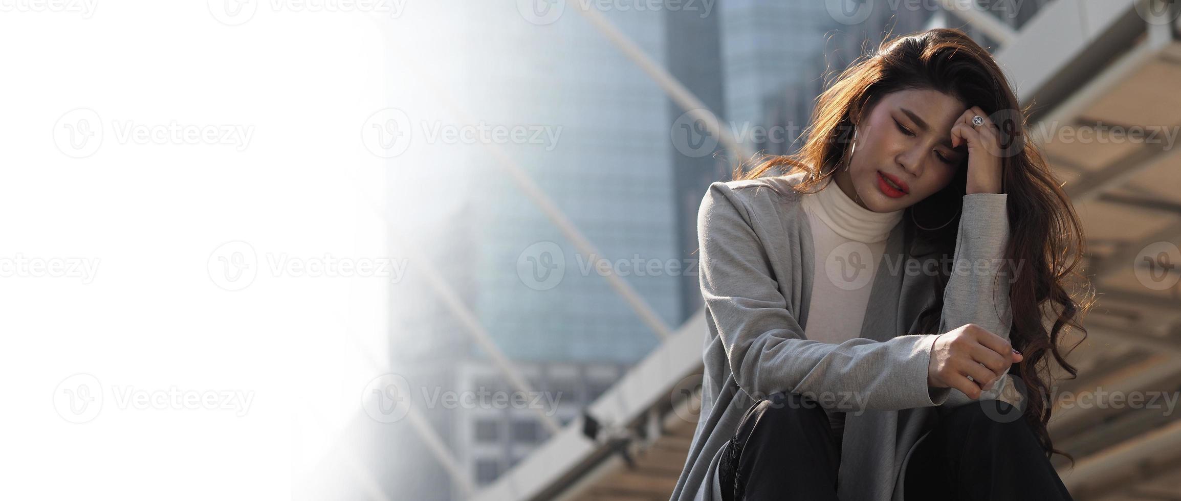 Lay off. Sacked. Fired business woman sitting on stairs of office building outside. photo