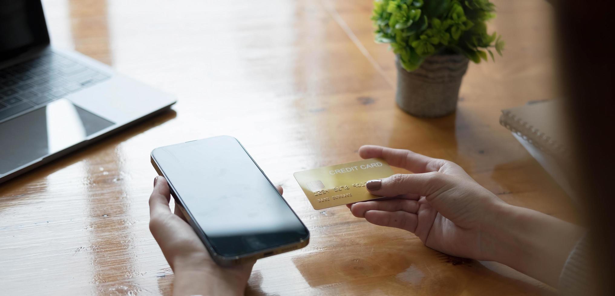 Online payment,Young woman's hands using computer and hand holding credit card for online shopping photo