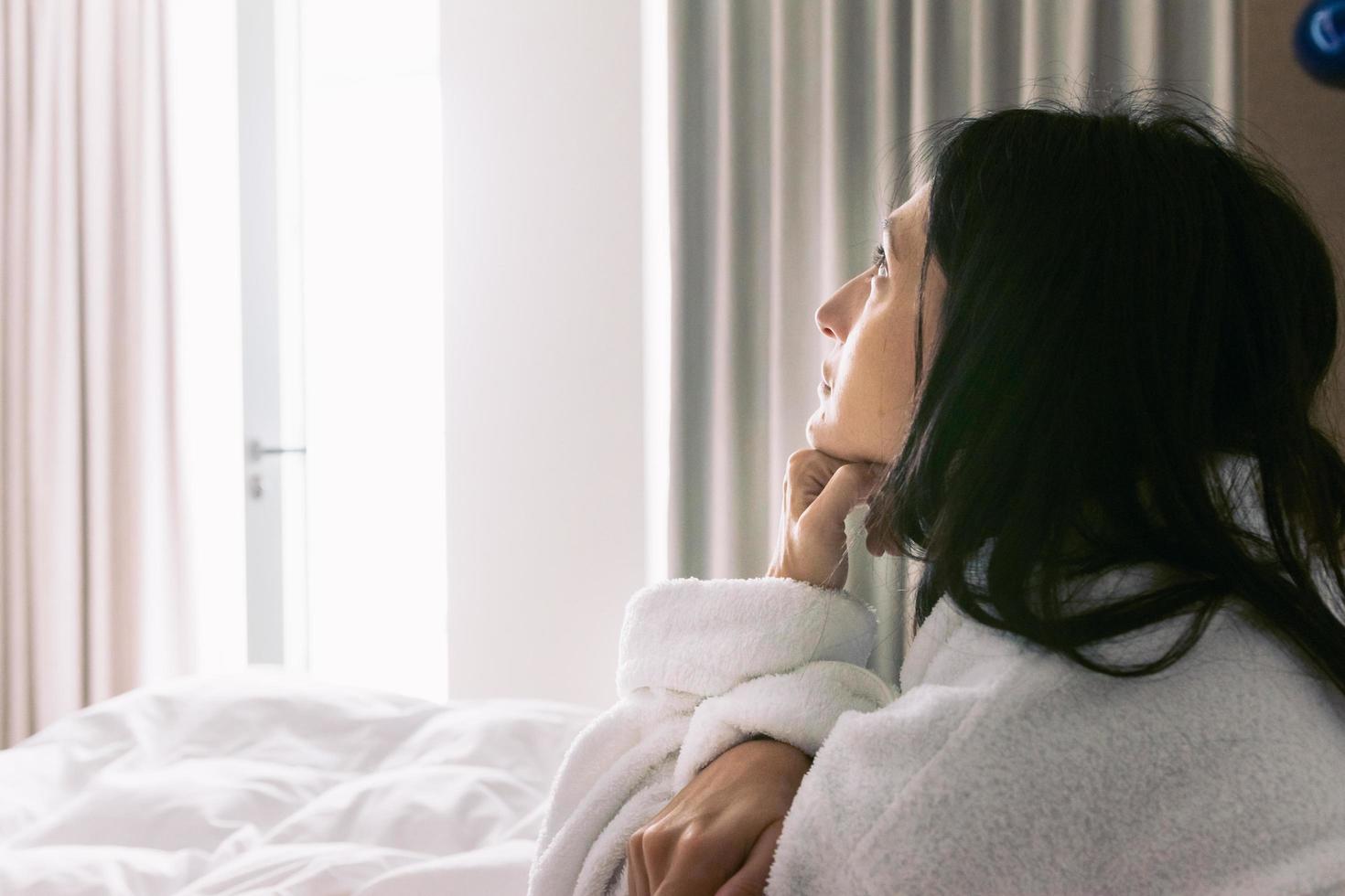 mujer en la cama pensativa foto