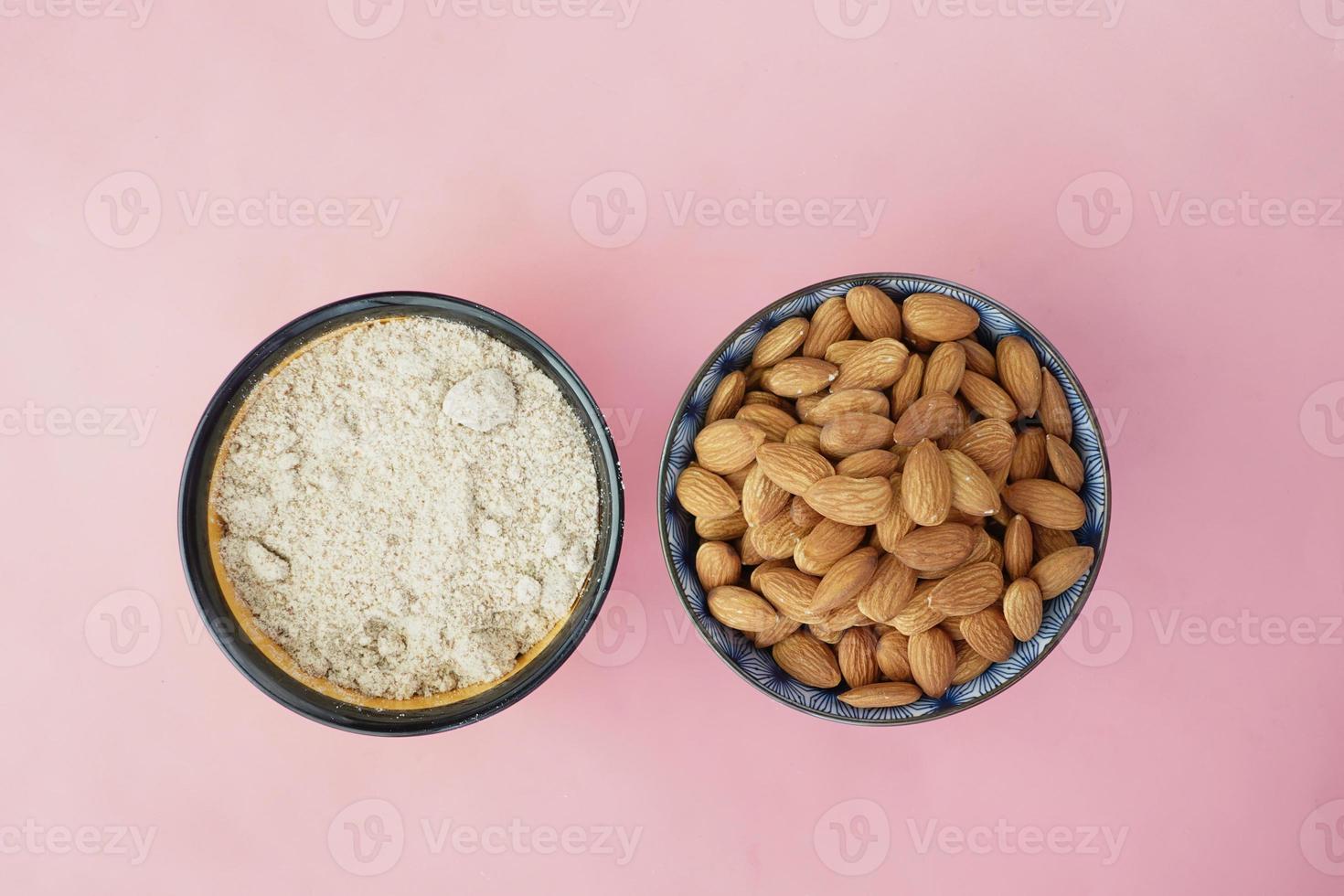 almond powder and almond in a bowl on pink photo
