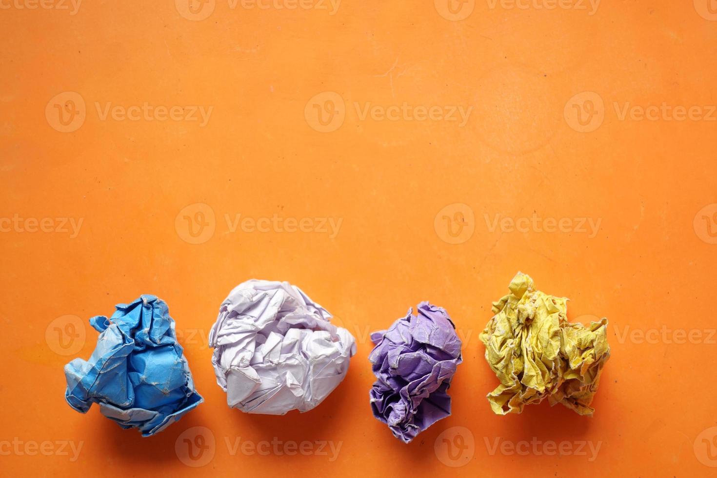 top view of crumpled paper balls on orange background photo