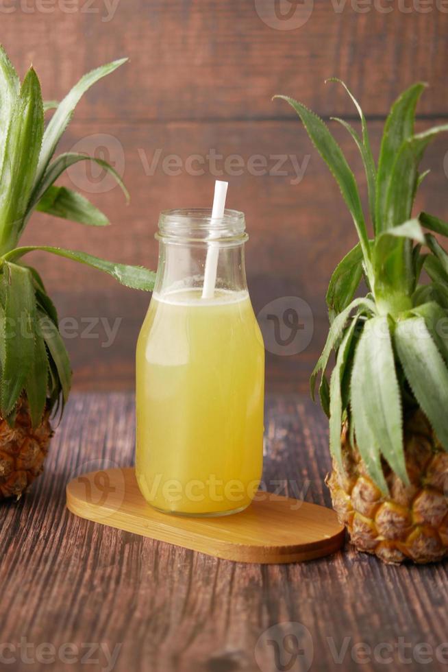 jugo de piña en una botella en la mesa foto