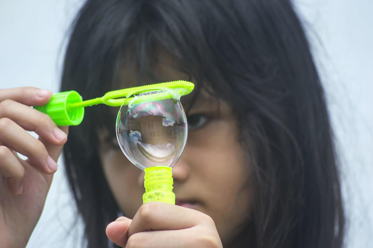 A girl holding a bubble maker and blowing them out. photo