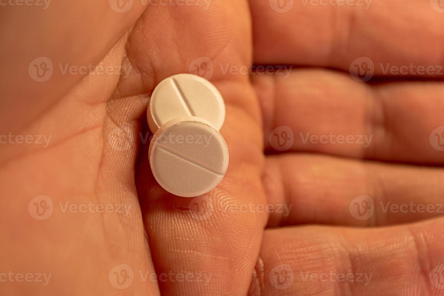 Two pills in the human palm photo