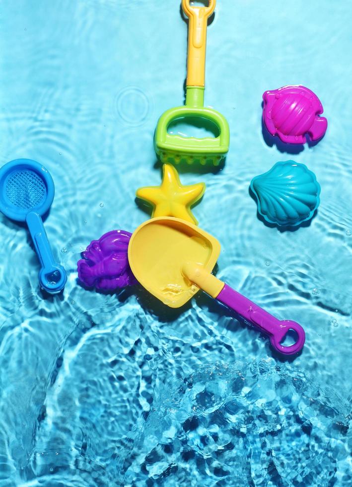 Children's beach toys on splashing water photo