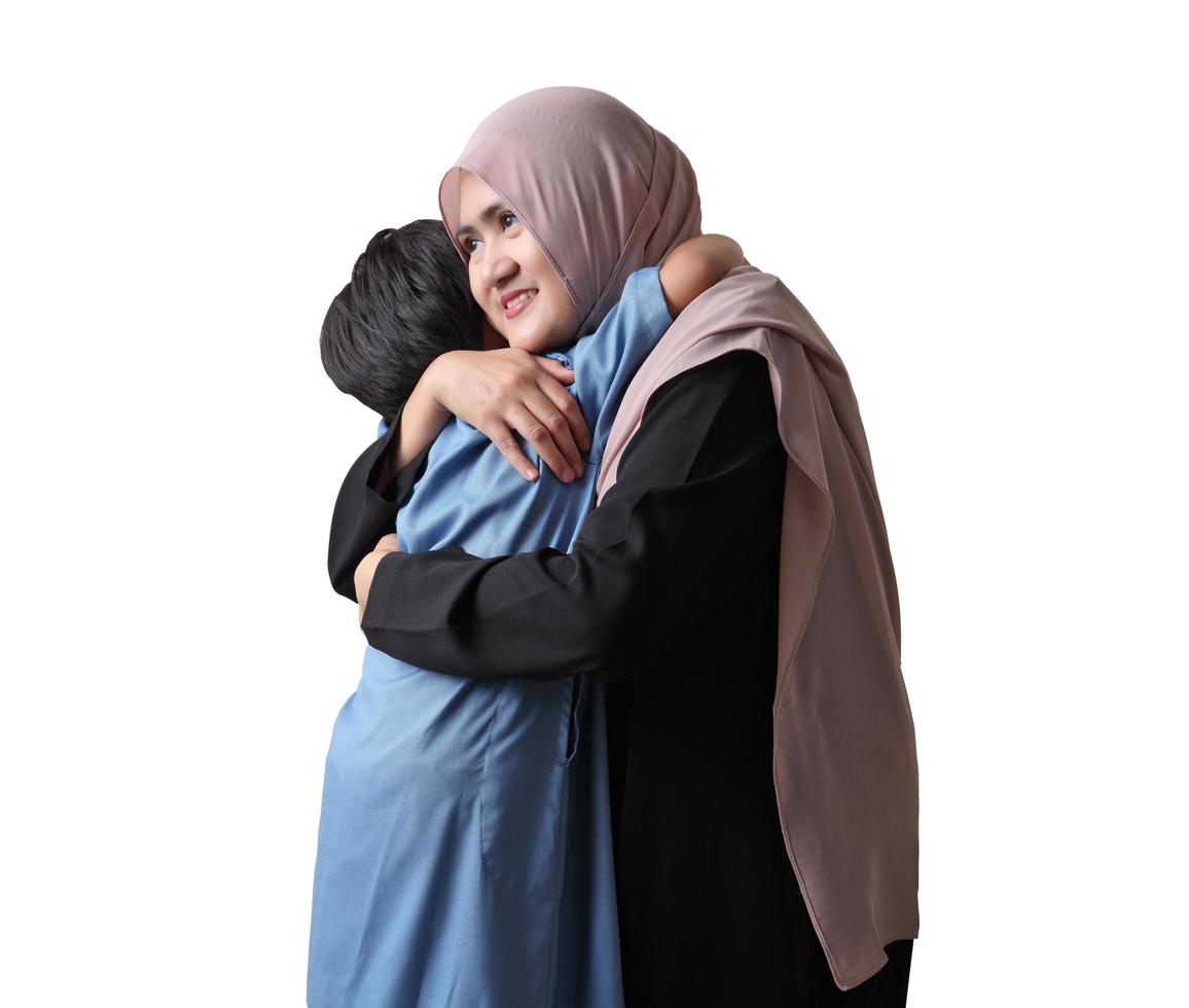 Young Muslim woman hugging and smiling with her little son on white background photo