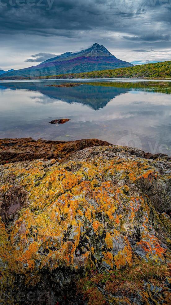 hermoso atardecer en la bahía ensenada zaratiegui en el parque nacional tierra del fuego, cerca de ushuaia y el canal beagle, con coloridos líquenes que cubren las rocas, patagonia, argentina, principios de otoño. foto