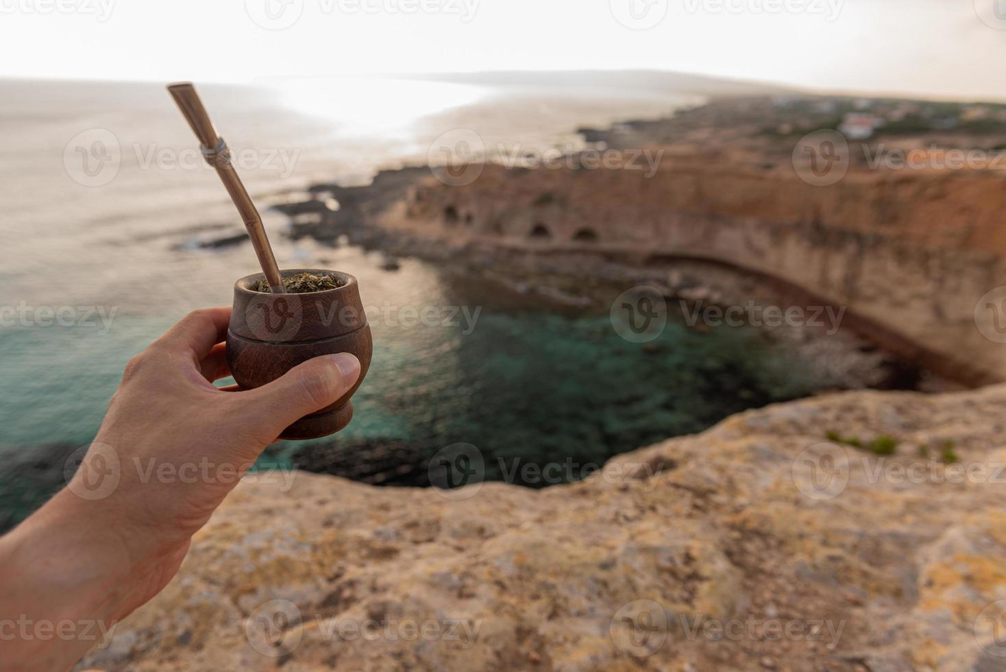 Man with small mate in hand on a Mediterranean beach. Mate is a typical drink from Paraguay, Argentina, Brazil and Uruguay. photo