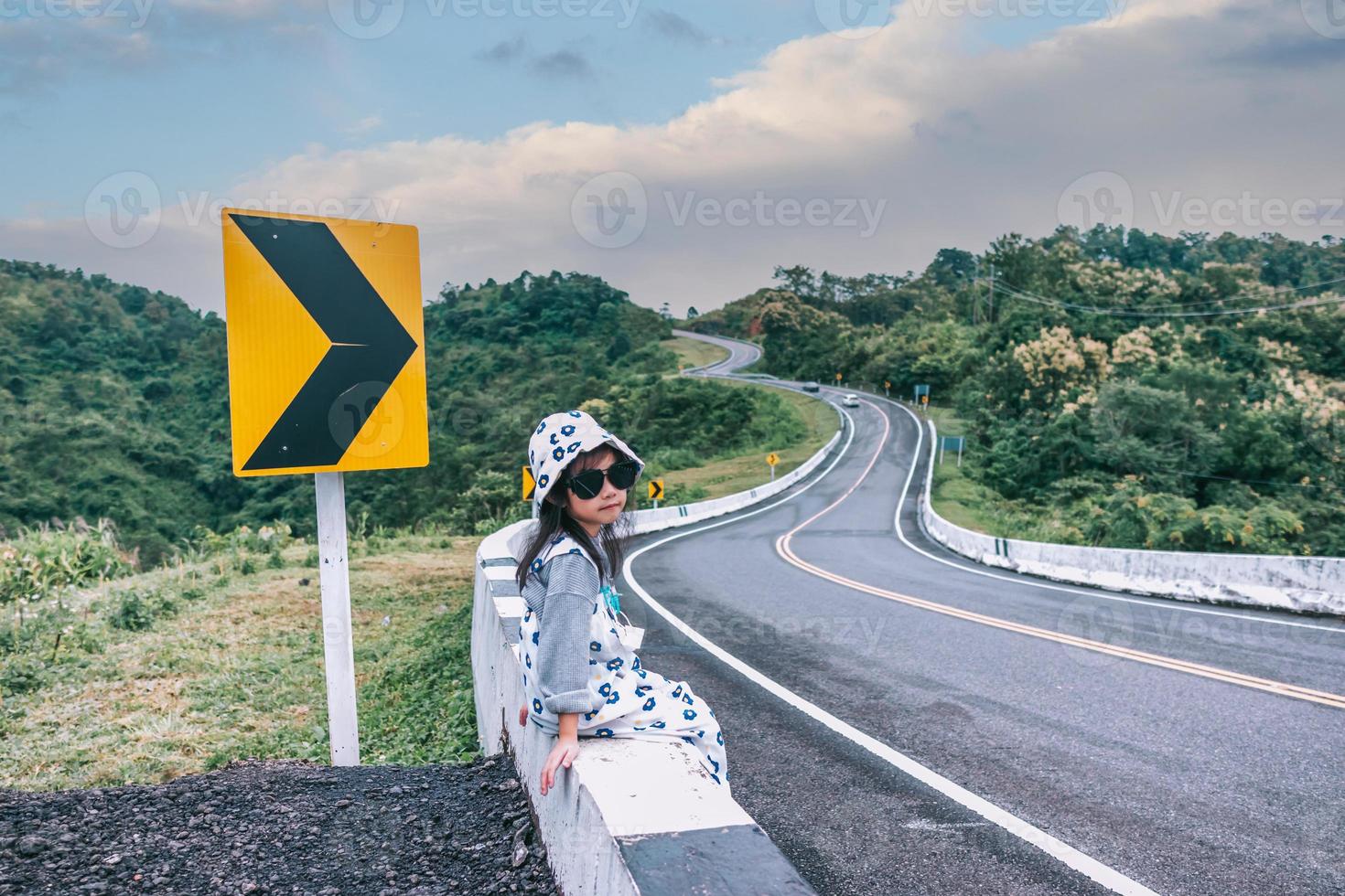 niña sentada en la carretera foto