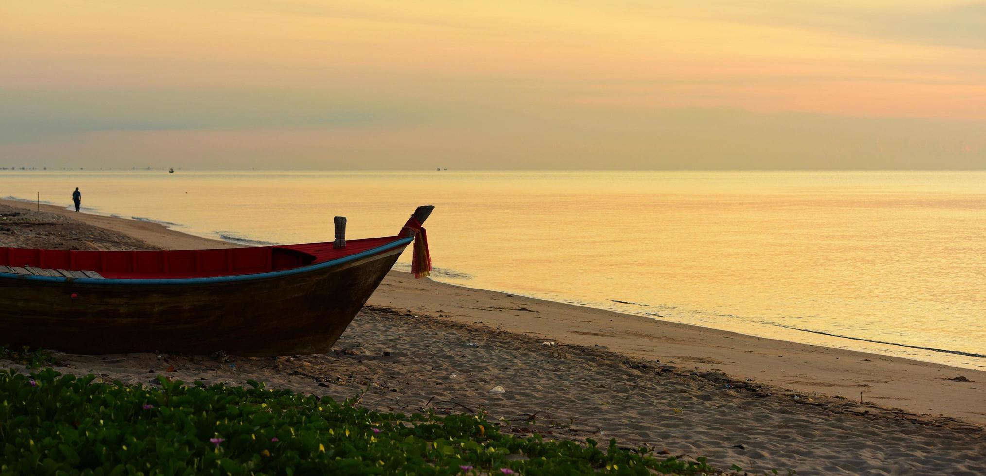 mar y cielo dorado amanecer y pequeños barcos de pesca foto