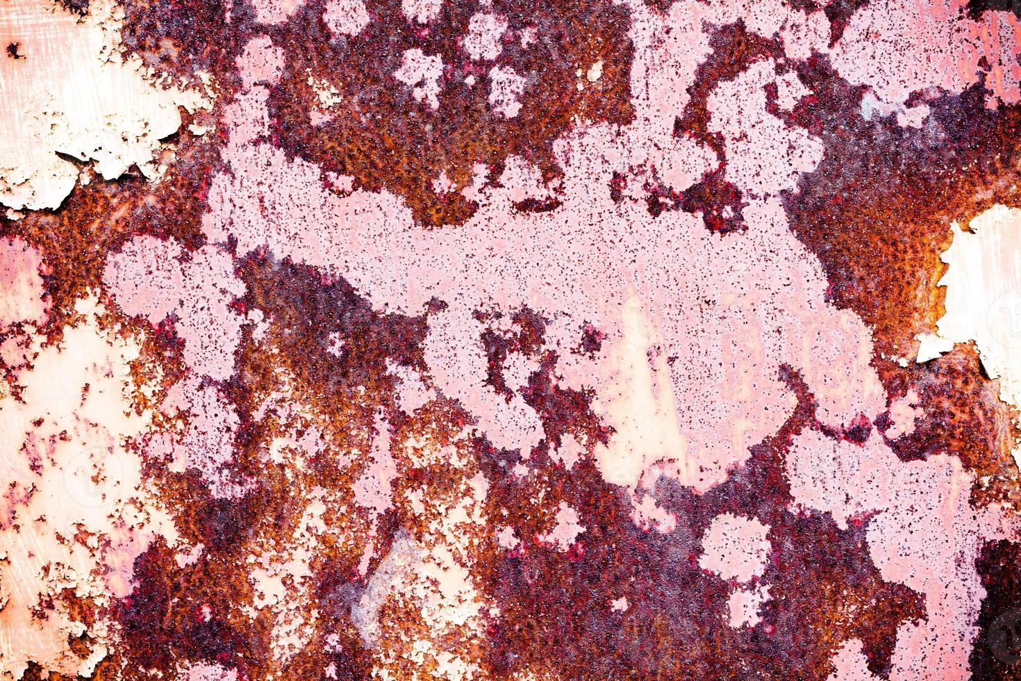 Brown grunge texture of an old metal wall covered in rust. Textured surface with an interesting pattern, dirty sheet metal with peeling paint. Weathered, rough and rust-eaten iron wall of the garage. photo